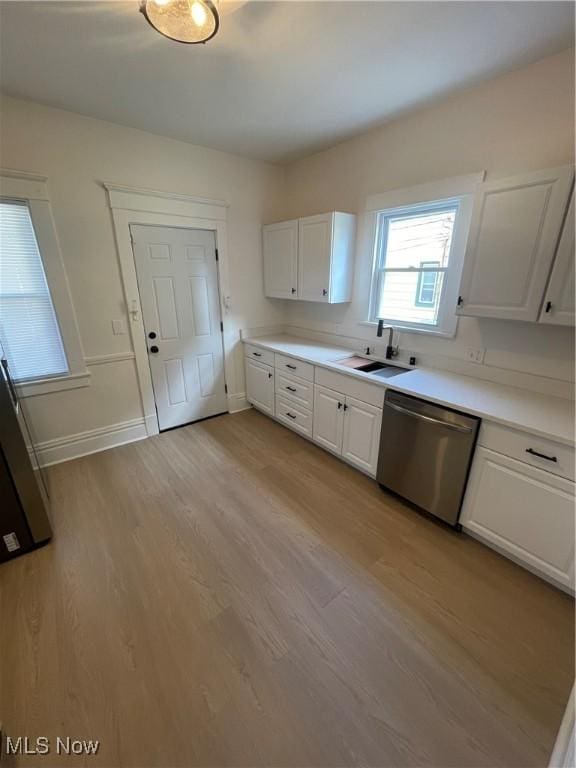 3363 E 125th St, Cleveland, OH 44120 - kitchen with dishwasher, white cabinets, light wood-style flooring, and light countertops