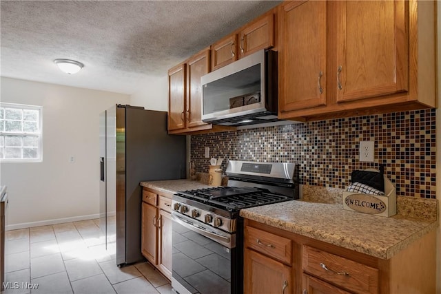 3917 Walker Rd, Walker, WV 26180 - kitchen featuring stainless steel appliances, brown cabinets, backsplash, light countertops, and a textured ceiling