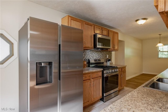 3917 Walker Rd, Walker, WV 26180 - kitchen featuring stainless steel appliances, tasteful backsplash, light countertops, decorative light fixtures, and light tile patterned floors
