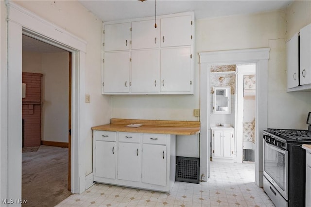 1407 Andrew St, Parkersburg, WV 26101 - kitchen with stainless steel gas stove, light flooring, light countertops, and white cabinets
