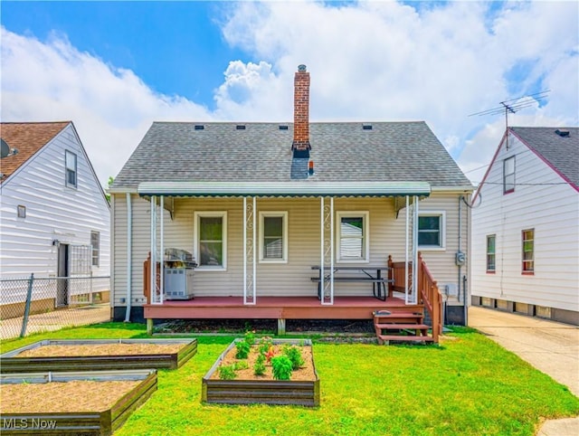 14507 Reddington Ave, Maple Heights, OH 44137 - rear view of house with a vegetable garden, a chimney, covered porch, and a shingled roof