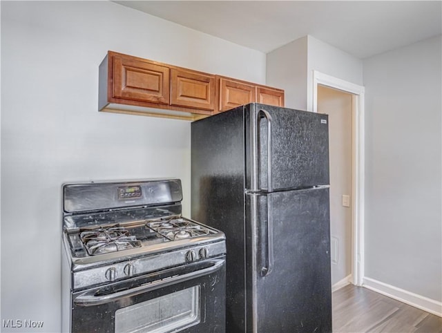 14507 Reddington Ave, Maple Heights, OH 44137 - kitchen featuring black appliances, wood finished floors, and brown cabinets