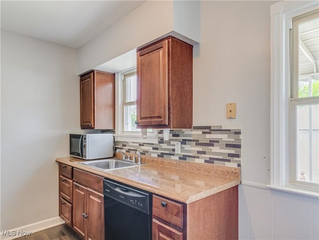 14507 Reddington Ave, Maple Heights, OH 44137 - kitchen featuring black dishwasher, healthy amount of natural light, backsplash, dark wood-type flooring, and wainscoting
