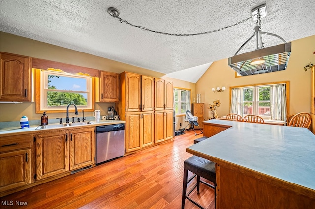 5050 Middle Rd, Conneaut, OH 44030 - kitchen featuring stainless steel dishwasher, light wood-style floors, light countertops, a textured ceiling, and a breakfast bar