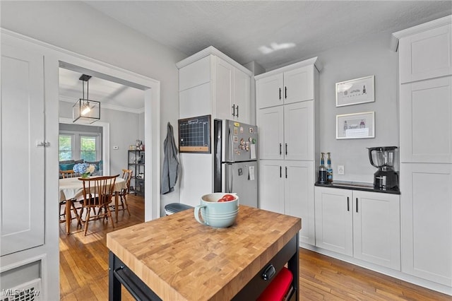 14317-14319 Bayes Ave, Lakewood, OH 44107 - kitchen featuring freestanding refrigerator, light wood-style flooring, white cabinetry, crown molding, and decorative light fixtures