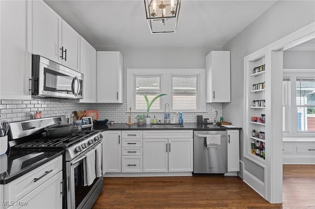 14317-14319 Bayes Ave, Lakewood, OH 44107 - kitchen featuring appliances with stainless steel finishes, dark countertops, dark wood-style floors, backsplash, and white cabinetry