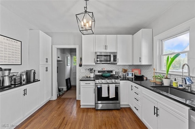 14317-14319 Bayes Ave, Lakewood, OH 44107 - kitchen with appliances with stainless steel finishes, dark countertops, tasteful backsplash, and plenty of natural light