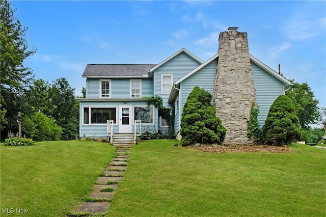 45 Mechanic St, Berlin Heights, OH 44814 - view of front facade featuring a front yard, a sunroom, and a chimney