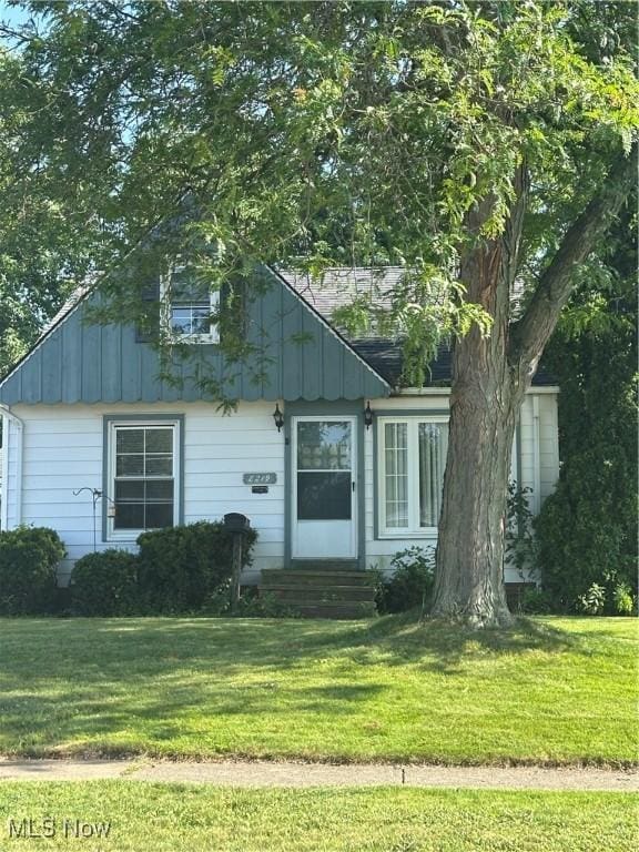 8219 Wainstead Dr, Parma, OH 44129 - view of front of house featuring entry steps, board and batten siding, and a front lawn