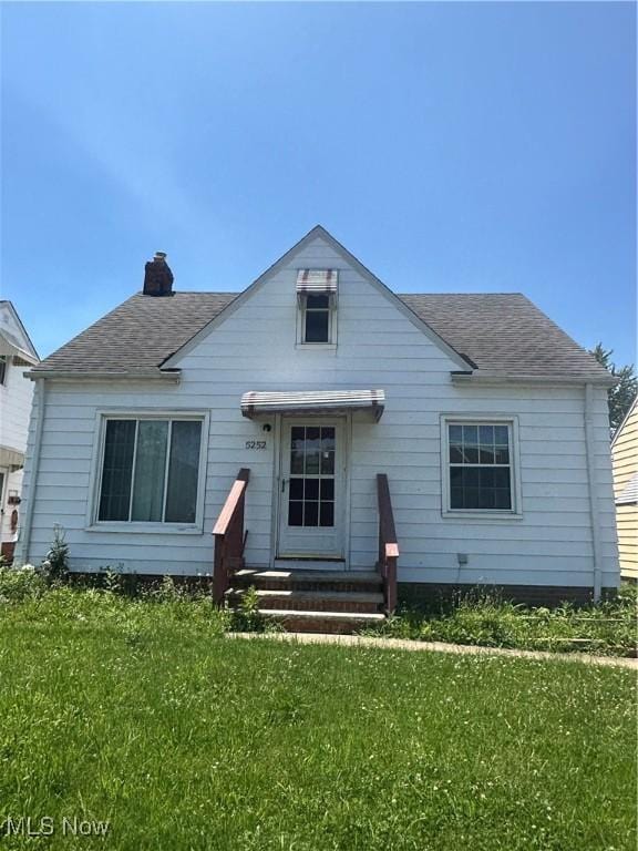 5252 W 45th St, Parma, OH 44134 - view of front of house featuring a front lawn, a chimney, and roof with shingles