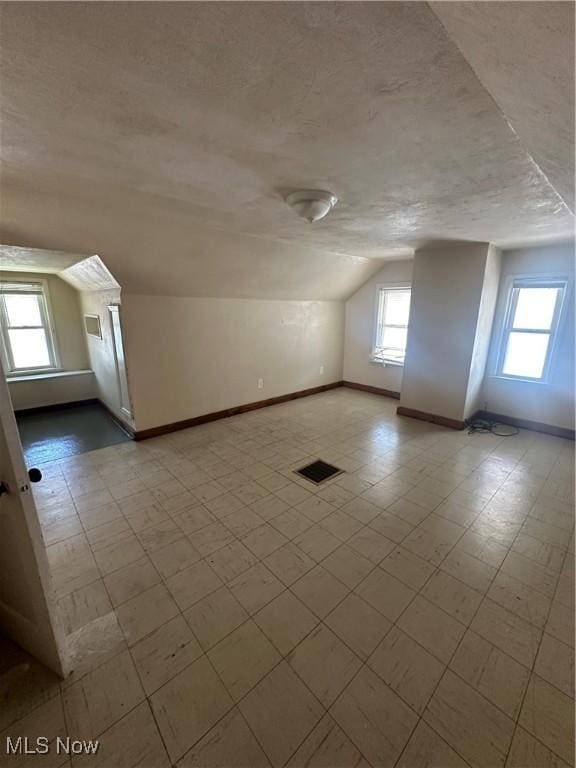 5252 W 45th St, Parma, OH 44134 - bonus room featuring a textured ceiling, vaulted ceiling, and tile patterned floors
