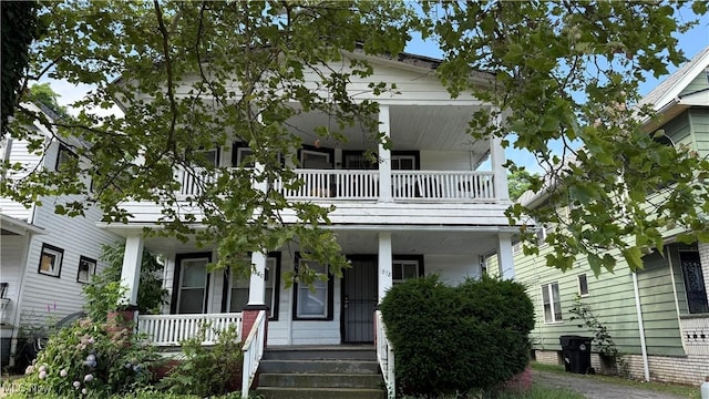 view of front of property with covered porch and a balcony