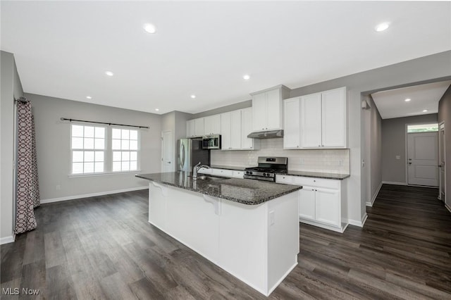 1637 Duncan Way, Streetsboro, OH 44241 - kitchen with appliances with stainless steel finishes, a kitchen island with sink, a kitchen bar, dark wood-style floors, and decorative backsplash