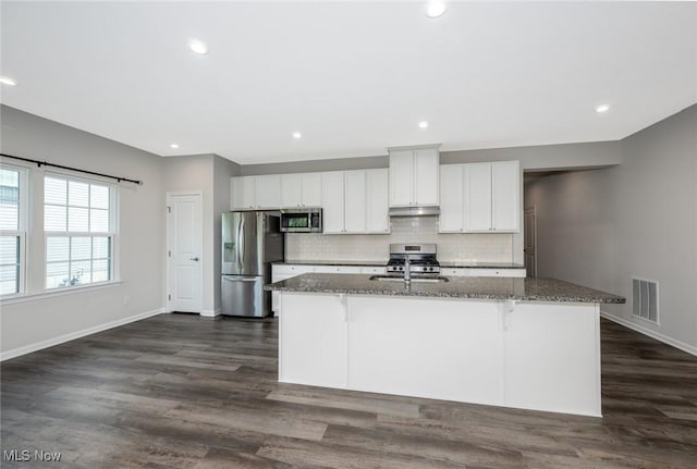1637 Duncan Way, Streetsboro, OH 44241 - kitchen with appliances with stainless steel finishes, dark stone counters, a center island with sink, a breakfast bar, and tasteful backsplash
