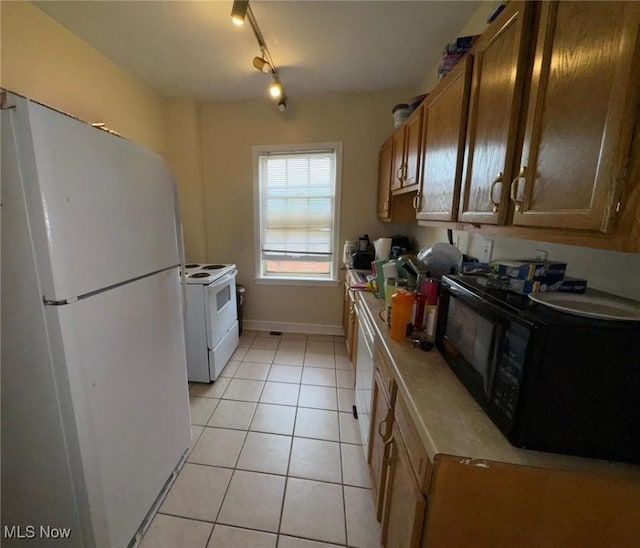 15610 Van Aken Blvd Unit 5, Shaker Heights, OH 44120 - kitchen with white appliances, light tile patterned floors, light countertops, and brown cabinetry