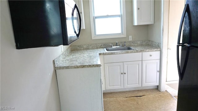 20737 Bowling Green Rd, Maple Heights, OH 44137 - kitchen with freestanding refrigerator, white cabinetry, and light countertops