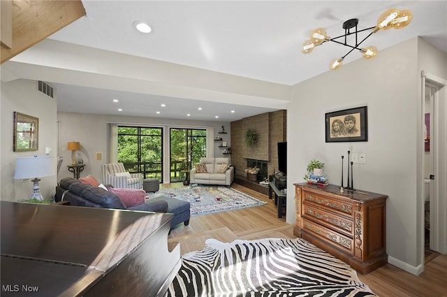 629-37 Fairington Oval, Aurora, OH 44202 - living area with a large fireplace, a chandelier, recessed lighting, and light wood-style floors