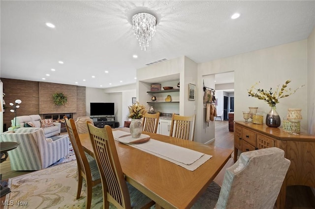 629-37 Fairington Oval, Aurora, OH 44202 - dining space with recessed lighting, a chandelier, light wood finished floors, and a fireplace