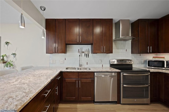 629-37 Fairington Oval, Aurora, OH 44202 - kitchen with appliances with stainless steel finishes, wall chimney exhaust hood, light wood-style flooring, light stone counters, and decorative backsplash