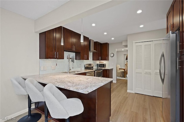 629-37 Fairington Oval, Aurora, OH 44202 - kitchen with stainless steel appliances, decorative backsplash, light wood finished floors, a peninsula, and light stone countertops