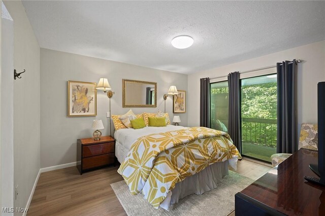 629-37 Fairington Oval, Aurora, OH 44202 - bedroom featuring wood finished floors, a textured ceiling, and access to outside