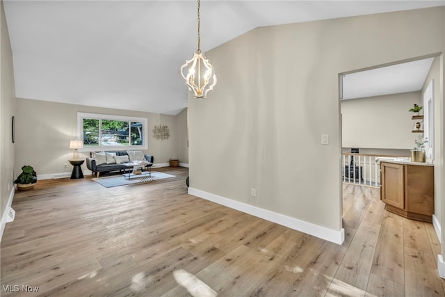 4499 Camellia Ln, North Olmsted, OH 44070 - living room with vaulted ceiling, a chandelier, and light wood-style floors