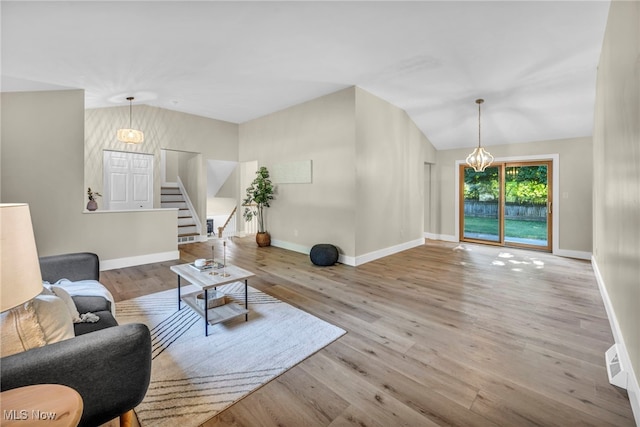 4499 Camellia Ln, North Olmsted, OH 44070 - living room with lofted ceiling, stairs, a chandelier, and wood finished floors