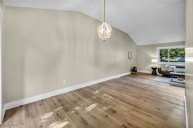 4499 Camellia Ln, North Olmsted, OH 44070 - unfurnished living room with vaulted ceiling, a chandelier, and wood finished floors