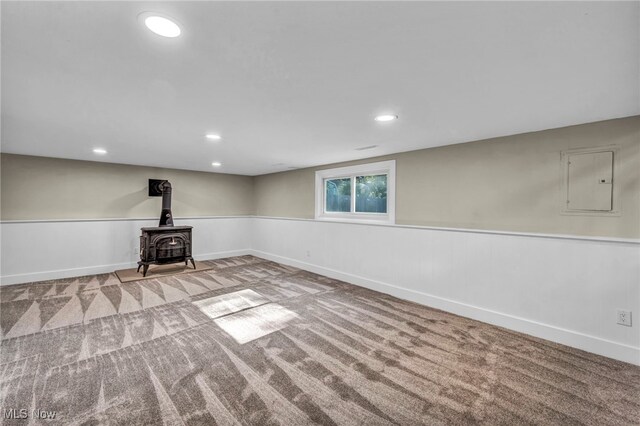 4499 Camellia Ln, North Olmsted, OH 44070 - below grade area featuring electric panel, carpet flooring, a wainscoted wall, a wood stove, and recessed lighting
