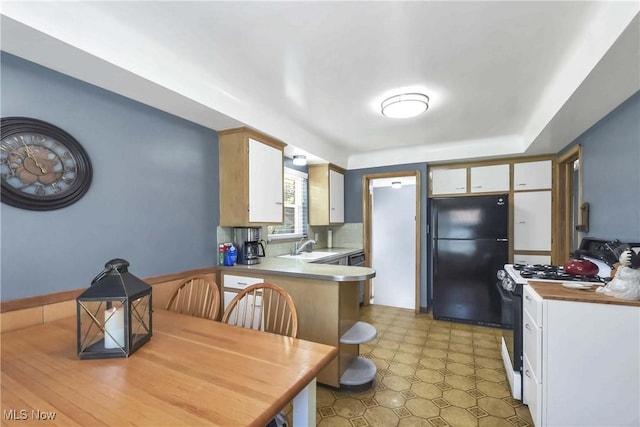 6713 Mackenzie Rd, North Olmsted, OH 44070 - kitchen with freestanding refrigerator, white range with gas cooktop, light flooring, a peninsula, and stainless steel dishwasher