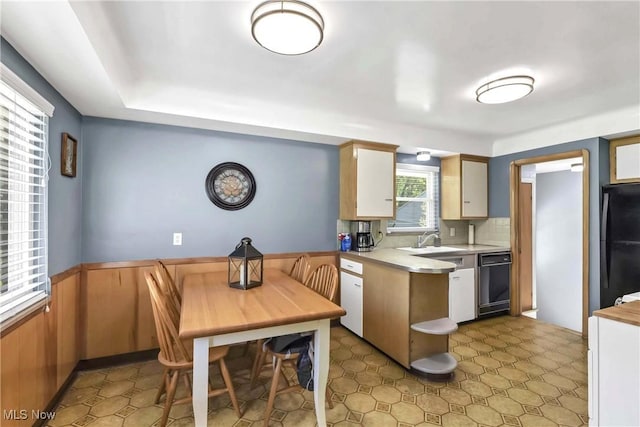 6713 Mackenzie Rd, North Olmsted, OH 44070 - kitchen with black appliances, light countertops, wainscoting, a peninsula, and tasteful backsplash