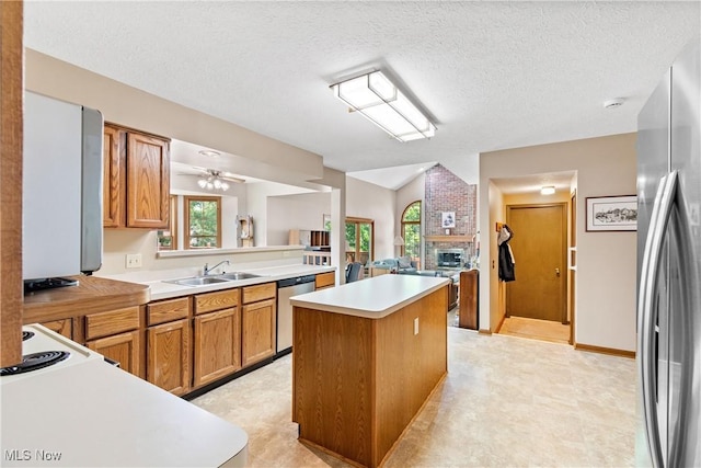 525 Bishop Pl, Berea, OH 44017 - kitchen featuring appliances with stainless steel finishes, a center island, brown cabinetry, light countertops, and a ceiling fan