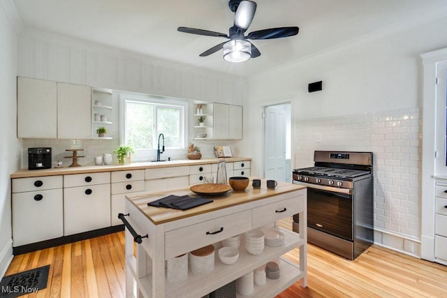 235 Elm St, Oberlin, OH 44074 - kitchen with open shelves, gas stove, tasteful backsplash, light wood finished floors, and ornamental molding