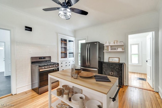 235 Elm St, Oberlin, OH 44074 - kitchen featuring stainless steel appliances, light wood-type flooring, crown molding, ceiling fan, and decorative backsplash