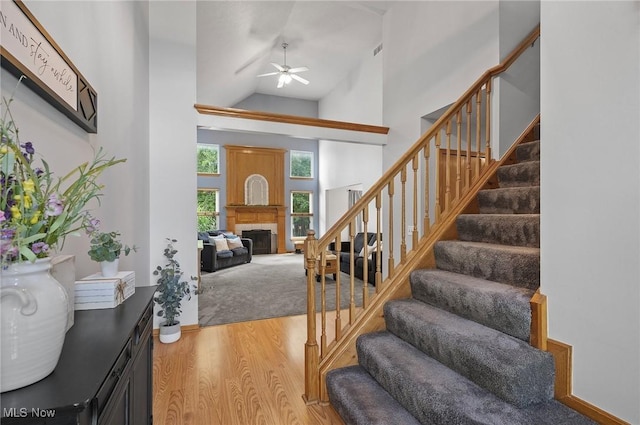 1036 Larkens Way, Medina, OH 44256 - entryway featuring wood finished floors, stairway, high vaulted ceiling, a fireplace, and ceiling fan