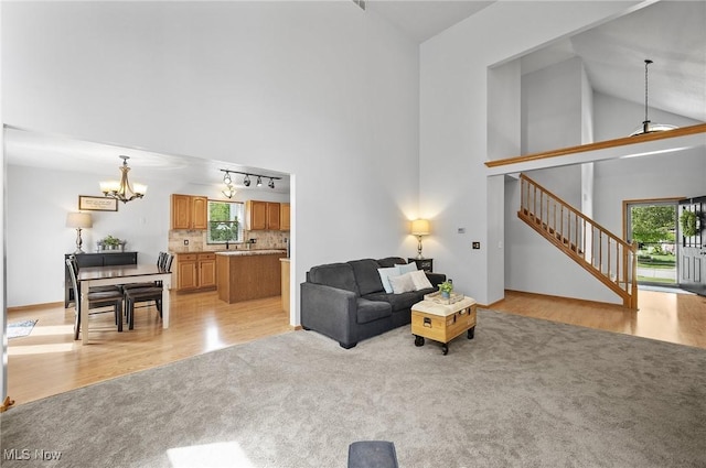 1036 Larkens Way, Medina, OH 44256 - living area with high vaulted ceiling, a chandelier, light wood-type flooring, stairway, and light carpet