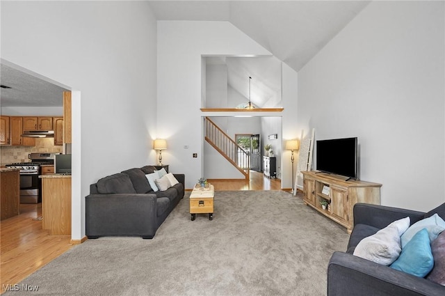 1036 Larkens Way, Medina, OH 44256 - living area featuring light wood finished floors, high vaulted ceiling, and stairway