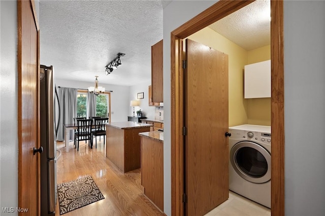 1036 Larkens Way, Medina, OH 44256 - laundry room featuring washer / clothes dryer, a chandelier, a textured ceiling, light wood-style floors, and track lighting