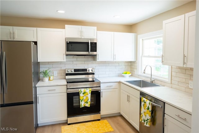5699 Colgate Ave, Austintown, OH 44515 - kitchen featuring stainless steel appliances, white cabinetry, light countertops, backsplash, and recessed lighting