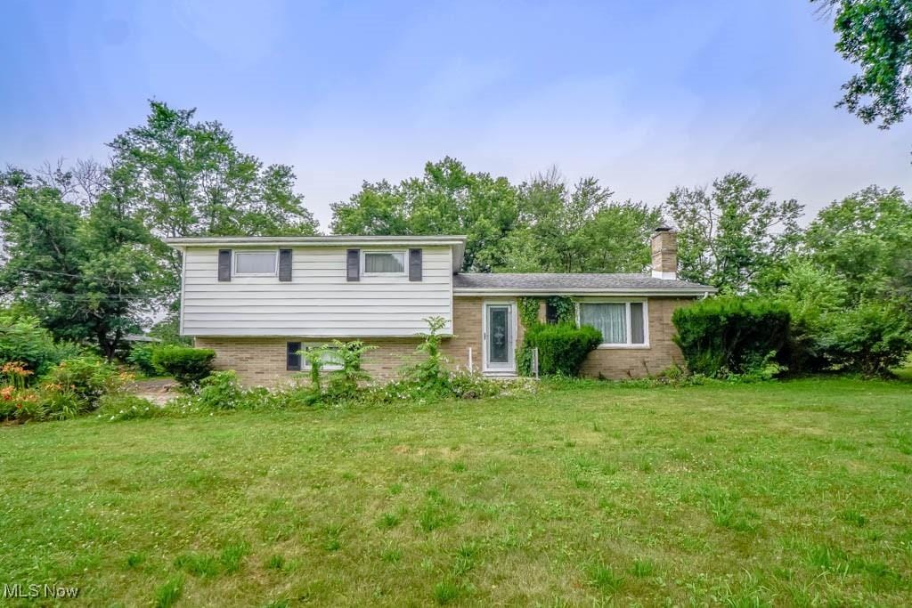 3223 Dueber Ave SW, Canton, OH 44706 - tri-level home with a front yard, a chimney, and brick siding