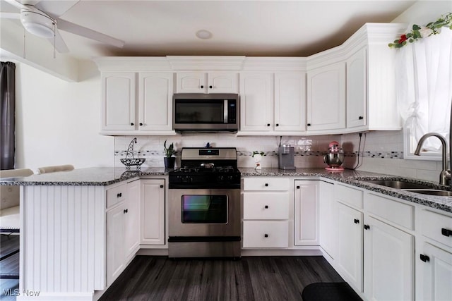 162 N Beverly Ave, Youngstown, OH 44515 - kitchen featuring stainless steel appliances, a peninsula, white cabinets, and dark wood-style flooring