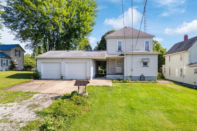 274 2nd St SW, Brewster, OH 44613 - rear view of property featuring concrete driveway, a garage, and a yard