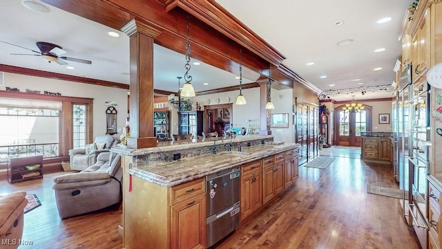 1431 Cedar Point Rd, Sandusky, OH 44870 - kitchen with crown molding, stainless steel dishwasher, wood finished floors, light stone countertops, and a ceiling fan