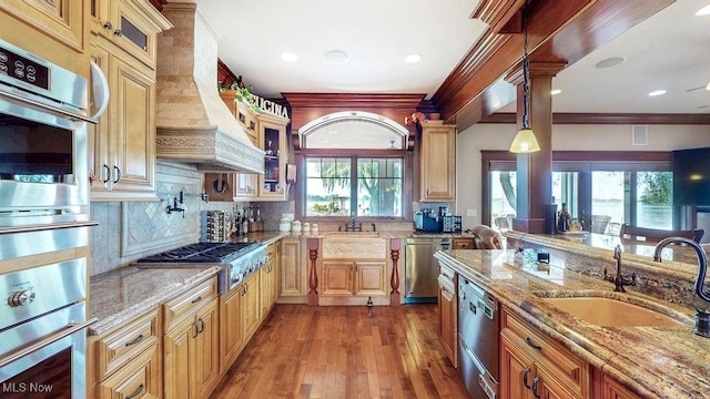 1431 Cedar Point Rd, Sandusky, OH 44870 - kitchen with appliances with stainless steel finishes, premium range hood, light stone countertops, glass insert cabinets, and ornamental molding