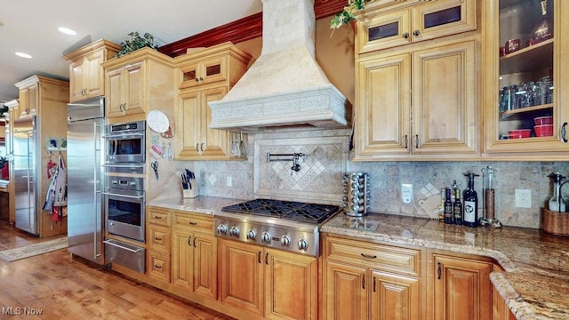 1431 Cedar Point Rd, Sandusky, OH 44870 - kitchen featuring custom range hood, stainless steel appliances, a warming drawer, and light stone countertops