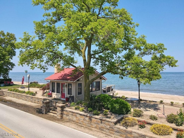 1431 Cedar Point Rd, Sandusky, OH 44870 - view of front of home featuring a water view, a tile roof, a chimney, and stucco siding