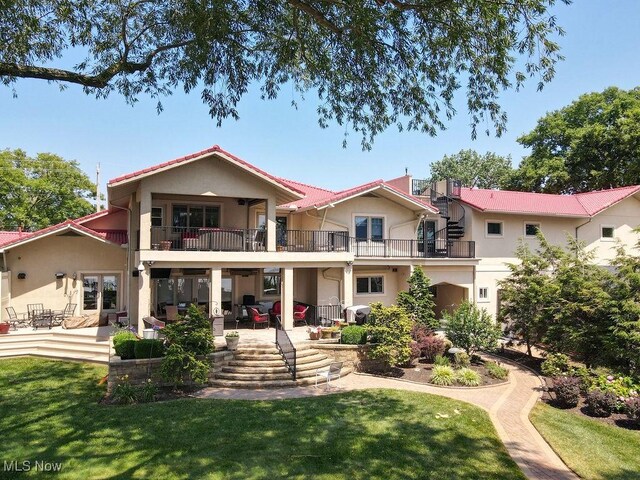 1431 Cedar Point Rd, Sandusky, OH 44870 - rear view of property featuring a balcony, stucco siding, a patio area, and a lawn
