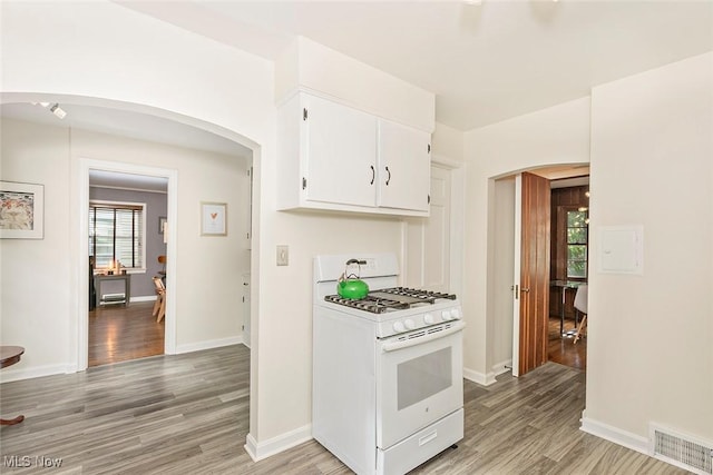 2215 S Belvoir Blvd, University Heights, OH 44118 - kitchen with white gas range oven, arched walkways, and light wood-style floors