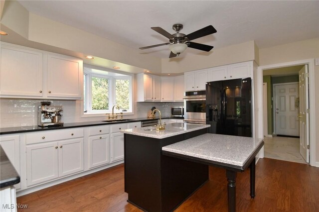 11919 Claridon Troy Rd, Chardon, OH 44024 - kitchen with black fridge with ice dispenser, white cabinets, backsplash, a ceiling fan, and a kitchen island with sink