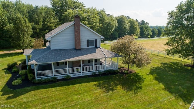 11919 Claridon Troy Rd, Chardon, OH 44024 - back of house with a porch, a chimney, a wooded view, and a shingled roof
